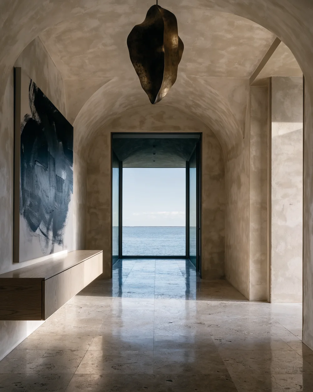Detail of plaster, white oak and travertine meeting in raking light